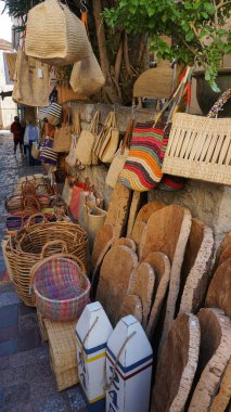 Le Lavandou, Cote d 'Azur, Fransa' daki pazarda satılık renkli el yapımı saman çantaları ve sepetlerin sergilenmesi. Doğal malzeme, sürdürülebilir ürün.