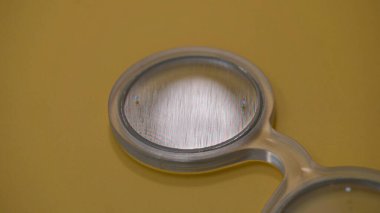 El bilgisayarı Bagolini gözlükleri ya da filtre optometrist göz muayenesi sırasında kullanılan tıbbi bir araç. Görme testi optometri ekipmanı. Bagolini çizgili lensler. Sarı arkaplan