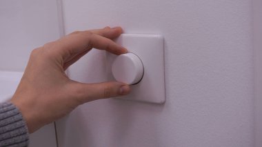 Parlaklığı ayarlamak ya da elektrik lambasını kapatmak. Enerji tasarrufu kavramı. Kapat.