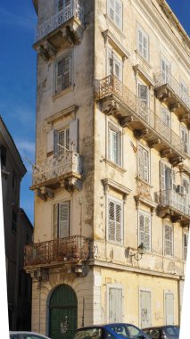 Corfu, Yunanistan Sep 19, 2022, Charming kırsal balkonları ve parlak güneş ışığı altında mimari ayrıntıları gösteren yıpranmış taş bina. Tarihi konutları tasvir etmek için mükemmel