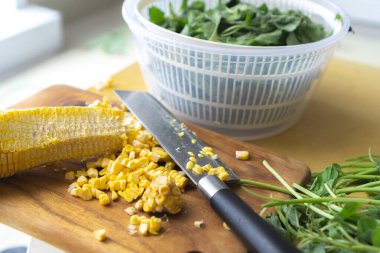 Tahtada mısır kesen kadın, ev yemeği konsepti.