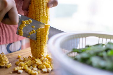 Tahtada mısır kesen kadın, ev yemeği konsepti.