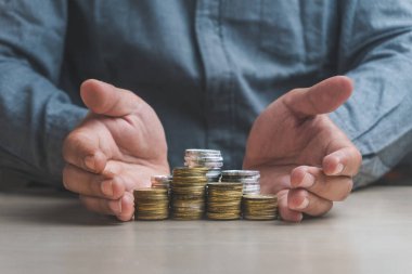 İşadamı, madeni para yığınını koruyor. Bankacılık için para sembolü faiz oranını yükseltiyor ya da ipotek yatırımını iş büyüme kavramından koruyor..