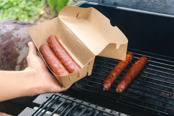 Pişmiş füme sosisler küçük işletme konsepti olan aşçı tarafından paketleniyor. 