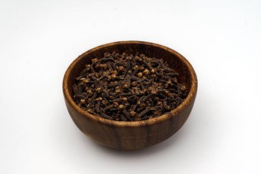 Karanfil dolu ahşap bir kase, beyaz bir arka planda izole edilmiş. 