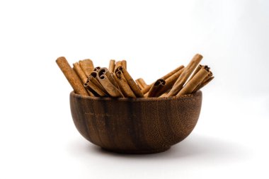 Tarçın dolu ahşap kase. Detaylı desenli, beyaz arka planda izole edilmiş.