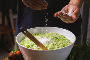 Soğutmadan önce kabaca doğranmış tatlı turşu çeşni malzemelerine tuz vermek.  