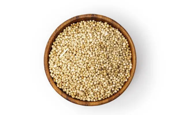 Tahta kasede kurumuş kişniş tohumları, beyaz arka planda izole edilmiş, baharat kataloğu konsepti, üst manzara