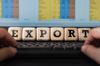 man on a computer working on data chart with export letter in wooden cube, concept of business, exporting industries clipart