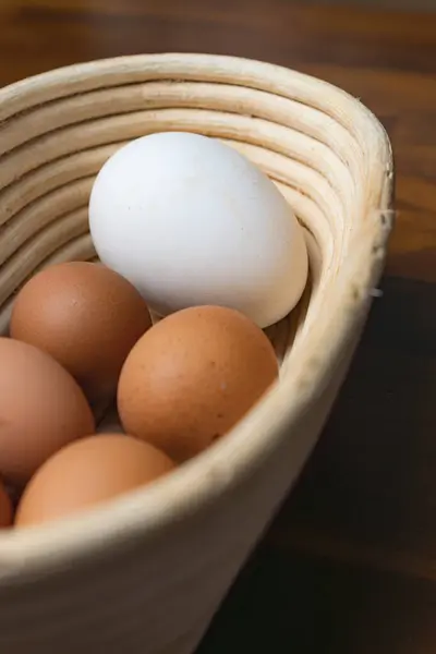 Tahta bir sepetin içinde kaz yumurtası ve tavuk yumurtası.