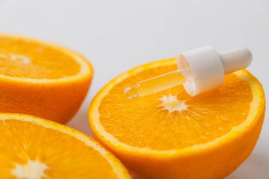 Bir yığın portakal diliminin tepesindeki boru, temel yağ özü kavramı, beyaz arka planda izole edilmiş.