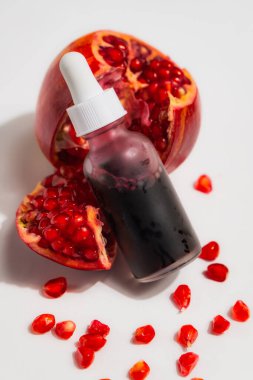 Cam damlacık şişesinde beyaz arka planda izole edilmiş, bir pipetle nar özü.