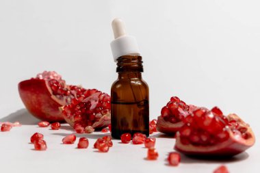 Kahverengi bir cam damlacıkta beyaz arka planda izole edilmiş pipetli nar yağı.