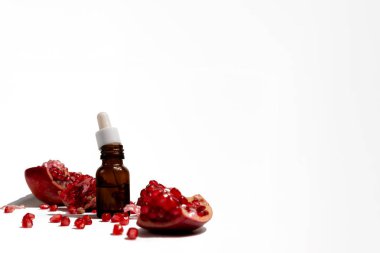 Kahverengi bir cam damlacıkta beyaz arka planda izole edilmiş pipetli nar yağı.