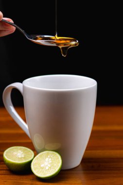 Bir fincan çay ve limonun içine bal serpiştirmek