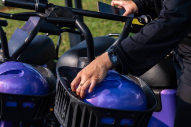 Kadın scooter sürmeden önce kask takıyor.