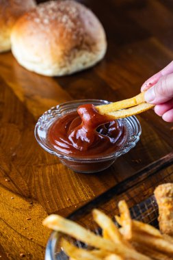 Tahta bir masada patates ve ketçap.