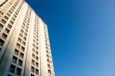 Açık mavi gökyüzüne karşı apartman binasının alçak açılı manzarası