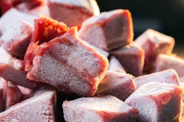 Paslanmaz çelik bir masada donmuş et küpü yığını, kapalı.