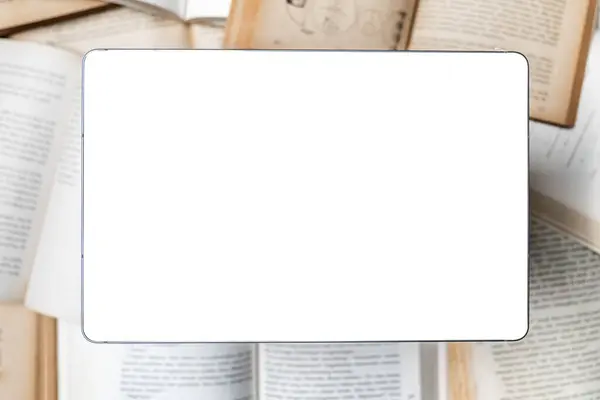 E- kitap kavramını temsil eden, açık bir kitap yığınının üzerinde beyaz ekran olan dijital bir tablet.