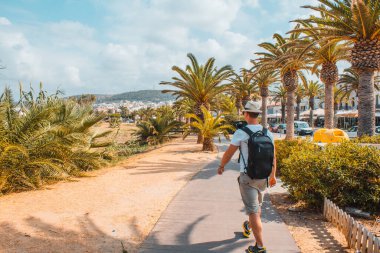 Sokakta palmiye ağacının yanında yürüyen bir adam. Yüksek kalite fotoğraf