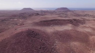 Destansı bir 4K insansız hava aracı Fuerteventura 'nın canlı kırmızı volkanik tepeleri ve çorak dokuları üzerinde uçuyor. Çöl benzeri ya da diğer dünyevi ortamları içeren projeler için mükemmel.. 