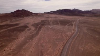 Drone, Fuerteventura 'daki Jandia Çölü' nün ortasında terk edilmiş bir uçak pistini yakalıyor. Çatlak beton berrak bir gökyüzünün altındaki kayalık volkanik yüzeye karışıyor.. 