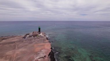 İnsansız hava aracı, Faro Punta de Jandia 'yı güney Fuerteventura' daki kayalık bir çöl kıyısında dirençli bir şekilde yakalar. Deniz feneri, doğal güzellik ve sessizlikle çevrili açık Atlantik 'e bakıyor.. 