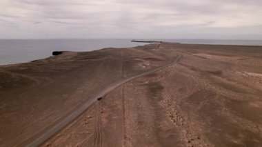 İnsansız hava aracı Fuerteventura 'daki Jandia' nın dramatik ve engebeli arazisinde yükseklere uçuyor. Volkanik tepelerden geçip ünlü Faro Punta de Jandia 'ya giden yalnız bir toprak yol.. 