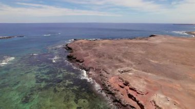 Hava aracı, çarpan volkanik uçurumların üzerinde ve Jandia yakınlarında kristal berraklığında turkuaz su üzerinde uçuyor. Fuerteventura 'nın güney kıyılarının ham dokularını ve canlı zıtlıklarını yakalar. Doğa ve seyahat içeriği yaratıcıları için mükemmel.