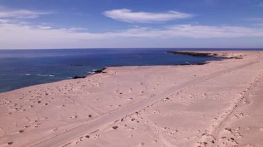 Hava aracı görüntüsü, Playa de Soledad yakınlarındaki tozlu sahil yolu boyunca turkuaz Atlantik sularıyla takip ediyor..