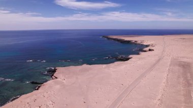 Fuerteventura 'daki Playa de Soledad yakınlarındaki engebeli kayalıklara ve turkuaz suya giden terk edilmiş bir havaalanının üzerinde havadan takip ediliyor..