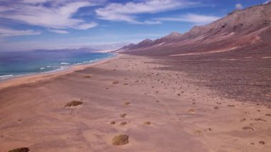 Geniş açılı çekim Fuerteventura 'daki Coffee Beach' in nefes kesici manzarasını yakalıyor. Resimde altın kumlar, turkuaz sular ve engebeli uçurumlar sergileniyor. Bu da onu seyahat, doğa ve manzara fotoğrafçılığı için ideal kılıyor.. 