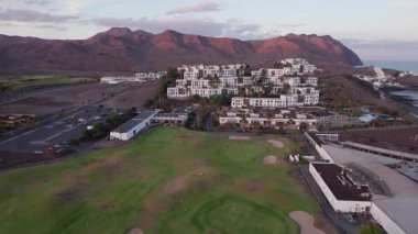 Dinamik hava görüntüleri Fuerteventura 'daki güneş panelleriyle donatılmış modern binaları yakalıyor. Görüntü, Kanarya Adaları 'nın engebeli güzelliği arasında sürdürülebilir yaşamı vurguluyor. Gayrimenkul, seyahat ve çevresel içerik için mükemmel.. 