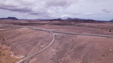 Detaylı hava görüntüleri Fuerteventura 'nın engebeli, çorak arazisini kesen düz bir yol yakalıyor. Görüntü, kırmızı toprağın, dağınık bitki örtüsünün ve uzak dağların katıksız güzelliğini vurguluyor. Bu da onu seyahat fotoğrafçılığı için ideal kılıyor..