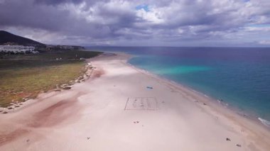 Altın saat günbatımı Fuerteventura 'daki canlı Morro Jable kasabasında sıcak renkler bırakıyor. Bu sakin sahne, yapılandırılmış kasaba ve engebeli arazi arasındaki kontrastı yakalar. Seyahat, doğa ve ilham verici fotoğrafçılık için mükemmeldir.. 