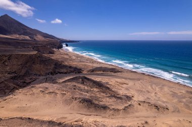 Yüksek çözünürlüklü insansız hava aracı Fuerteventura adasında engebeli volkanik kıyı şeridi ve derin mavi okyanus sularının görüntüsü.. 