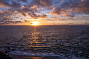 İspanya, Fuerteventura 'da gün batımında parlak altın ve turuncu gökyüzü yansıyor.. 