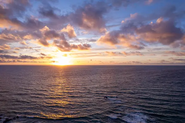Gece manzaralı kayalık sahil kayalıkları ve canlı okyanus günbatımı La Pared köyü yakınlarında.. 