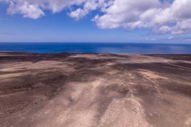 Jandia, Fuerteventura 'daki yuvarlanan tepelerin yakınlarında dönen bir yolu yakalayan muhteşem hava görüntüleri. Görüntü, yuvarlanan tepelerin doğal güzelliği ile yapılandırılmış yol arasındaki zıtlığı gösteriyor. Yolculuk macerası fotoğrafçılığı için mükemmel.. 