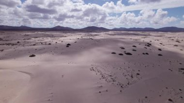 Dinamik hava görüntüleri Fuerteventura 'daki sahil kayalıkları üzerinde nefes kesen günbatımını gösteriyor. Görüntü, gökyüzünün canlı renklerini, turkuaz suları ve engebeli araziyi, seyahat, gayrimenkul ve yaşam tarzı fotoğrafçılığı için ideal olanı yakalıyor.. 