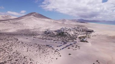 Dinamik hava görüntüleri Fuerteventura 'daki Costa Calma sahilinin yakınındaki sevimli köyü gösteriyor. Görüntü, yapılandırılmış binalar ve engebeli arazi arasındaki zıtlığı, seyahat, emlak ve yaşam tarzı fotoğrafçılığı için ideal olanı yakalıyor.. 