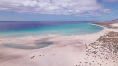 Fuerteventura 'daki büyüleyici Costa Calma plajını gösteren muhteşem hava görüntüleri. Görüntü, kumlu sahillerin, dağınık kayaların ve turkuaz suların eşsiz dokusunu sergiliyor. Seyahat, gayrimenkul ve yaşam tarzı fotoğrafçılığı için mükemmel.. 