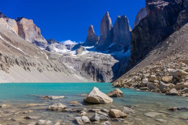 Torres del Paine dağları Şili 'deki Patagonya And Dağları ulusal parkı. Güney Amerika dağ manzarası. Güneşli bir günde, Los Cuernos, Torres del Paine ve Paine Grande göl kıyısında tepeler.