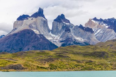 Torres del Paine dağları Şili 'deki Patagonya And Dağları ulusal parkı. Güney Amerika dağ manzarası. Güneşli bir günde, Los Cuernos, Torres del Paine ve Paine Grande göl kıyısında tepeler.