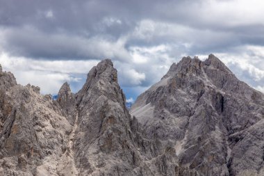 Dolomiti Alpleri güzel dağ manzarası. Dolomitlerde Rocky kulesi zirveleri. Yeşil dağ vadisindeki yürüyüş yolunda yaz manzarası ve bulutlu mavi gökyüzü.