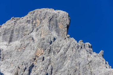 Dolomiti Alpleri güzel dağ manzarası. Dolomitlerde Rocky kulesi zirveleri. Yeşil dağ vadisindeki yürüyüş yolunda yaz manzarası ve bulutlu mavi gökyüzü.