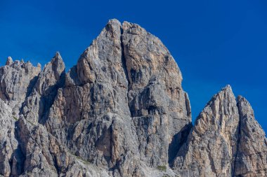 Dolomiti Alpleri güzel dağ manzarası. Dolomitlerde Rocky kulesi zirveleri. Yeşil dağ vadisindeki yürüyüş yolunda yaz manzarası ve bulutlu mavi gökyüzü.