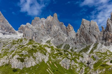 Dolomiti Alpleri güzel dağ manzarası. Dolomitlerde Rocky kulesi zirveleri. Yeşil dağ vadisindeki yürüyüş yolunda yaz manzarası ve bulutlu mavi gökyüzü.