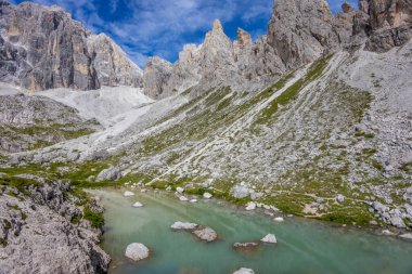 Dolomiti Alpleri güzel dağ manzarası. Dolomitlerde Rocky kulesi zirveleri. Yeşil dağ vadisindeki yürüyüş yolunda yaz manzarası ve bulutlu mavi gökyüzü.